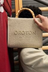 Profile view of model wearing the Oroton Lane Straw Tote in Laurel and Woven Straw With Leather Trim for Women