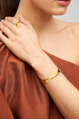 Profile view of model wearing the Oroton Ribbon Bangle in Gold and  for Women