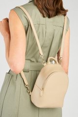 Profile view of model wearing the Oroton Inez Mini Backpack in Fawn and  for Women