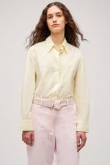 Profile view of model wearing the Oroton Wren Poplin Shirt in Lemon and Made from 100% poplin cotton  for Women