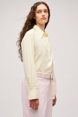 Profile view of model wearing the Oroton Wren Poplin Shirt in Lemon and Made from 100% poplin cotton  for Women