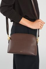 Profile view of model wearing the Oroton Inez Slim Crossbody in Coffee Bean and Shiny Soft Saffiano exterior for Women