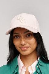 Profile view of model wearing the Oroton Oro Logo Cap in  and High-quality 100% cotton   for Women