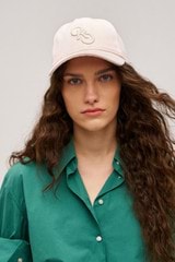 Profile view of model wearing the Oroton Oro Logo Cap in  and High-quality 100% cotton   for Women