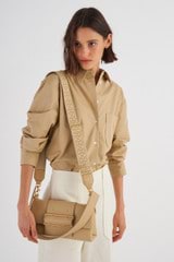 Profile view of model wearing the Oroton Logo Bag Strap in  and Smooth Leather And Webbing for Women