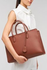 Profile view of model wearing the Oroton Muse 15" Worker Tote in Barn Red and Saffiano leather material for Women