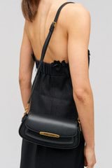 Profile view of model wearing the Oroton Nelle Baguette in Black and Smooth leather material for Women