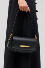 Profile view of model wearing the Oroton Nelle Baguette in Black and Smooth leather material for Women