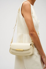 Profile view of model wearing the Oroton Nelle Baguette in Antique Cream and Smooth leather material for Women