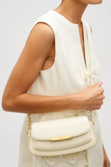 Profile view of model wearing the Oroton Nelle Baguette in Antique Cream and Smooth leather material for Women