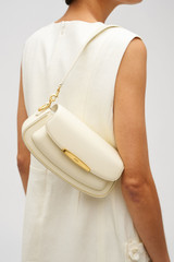 Profile view of model wearing the Oroton Nelle Baguette in Antique Cream and Smooth leather material for Women