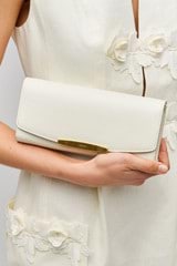 Profile view of model wearing the Oroton Nelle Texture Clutch in Clotted Cream and Embossed leather material for Women