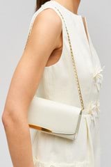 Profile view of model wearing the Oroton Nelle Texture Clutch in Clotted Cream and Embossed leather material for Women