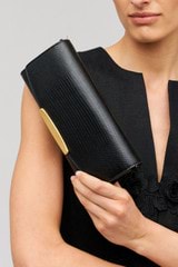 Profile view of model wearing the Oroton Nelle Texture Clutch in Black and Embossed leather material for Women