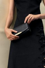 Profile view of model wearing the Oroton Nelle Texture Clutch in Black and Embossed leather material for Women