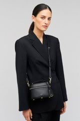 Profile view of model wearing the Oroton Muse Vanity Crossbody in Black and Saffiano Leather material for Women