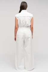 Profile view of model wearing the Oroton Wide Curved Leg Pant in White and 100% cotton material for Women