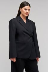 Profile view of model wearing the Oroton Wrap Blazer in Black and 98% wool,  2% elastane material for Women