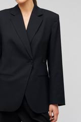 Profile view of model wearing the Oroton Wrap Blazer in Black and 98% wool,  2% elastane material for Women