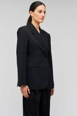 Profile view of model wearing the Oroton Wrap Blazer in Black and 98% wool,  2% elastane material for Women