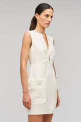 Profile view of model wearing the Oroton Rosebud Lace Mini Dress in Soft Cream and 100% linen material for Women