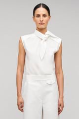 Profile view of model wearing the Oroton Sleeveless Tie Neck Shirt in White and 100% cotton material for Women