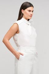 Profile view of model wearing the Oroton Sleeveless Tie Neck Shirt in White and 100% cotton material for Women