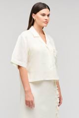 Profile view of model wearing the Oroton Rosebud Lace Camp Shirt in Soft Cream and 100% linen material for Women