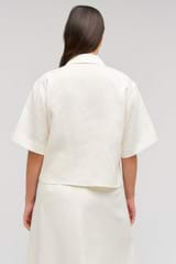 Profile view of model wearing the Oroton Rosebud Lace Camp Shirt in Soft Cream and 100% linen material for Women