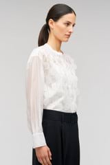 Profile view of model wearing the Oroton Scallop Lace Overshirt in White and 85% Tencel 15% Polyester for Women