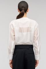 Profile view of model wearing the Oroton Scallop Lace Overshirt in White and 85% Tencel 15% Polyester for Women