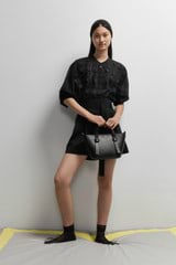 Profile view of model wearing the Oroton Scallop Lace Overshirt in Black and 85% Tencel 15% Polyester for Women