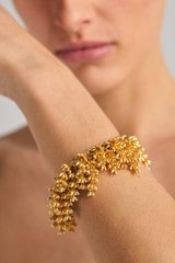Profile view of model wearing the Oroton Riley Layered Bracelet in Worn Gold and Brass Base With 18CT Gold Plating /Cubic Zirconia for Women