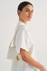 Profile view of model wearing the Oroton Tate Small Day Bag in Paper White and Pebble Leather for Women