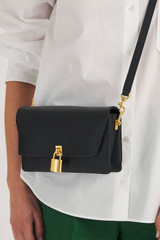 Profile view of model wearing the Oroton Tate Small Day Bag in Black and Pebble Leather for Women