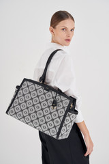 Profile view of model wearing the Oroton Lena Baby Bag With Mat & 15" Laptop Bag in Black and Oroton Signature Recycled Jacquard Fabric. Smooth Leather for Women