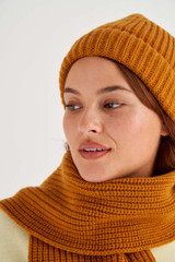 Profile view of model wearing the Oroton Woods Knit Beanie in Tan and 100% Merino Wool for Women