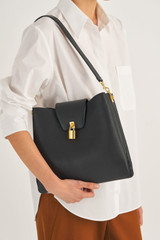 Profile view of model wearing the Oroton Tate Hobo in Black and Pebble Leather for Women