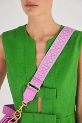 Profile view of model wearing the Oroton Logo Bag Strap in Fuchsia and 45Mm Wide Logo Jacquard Webbing With Leather Trims for Women