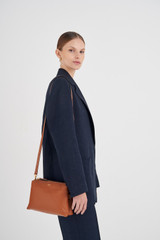Profile view of model wearing the Oroton Sadie Crossbody in Toffee and Pebble Leather for Women