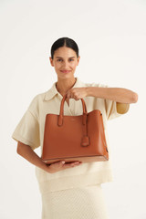 Profile view of model wearing the Oroton Muse Three Pocket Day Bag in Cognac and Two Tone Saffiano Leather / for Women