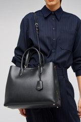 Profile view of model wearing the Oroton Muse Three Pocket Day Bag in Black and Two Tone Saffiano Leather / for Women