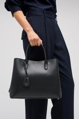 Profile view of model wearing the Oroton Muse Three Pocket Day Bag in Black and Two Tone Saffiano Leather / for Women