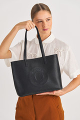 Profile view of model wearing the Oroton Polly Medium Tote in Black and Pebble Leather for Women