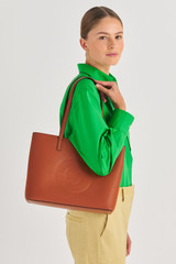 Profile view of model wearing the Oroton Polly Medium Tote in Cognac and Pebble Leather for Women