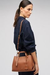 Profile view of model wearing the Oroton Margot Mini Day Bag in Whiskey and Pebble Leather for Women