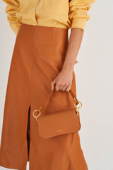 Profile view of model wearing the Oroton Liv Small Day Bag in Maple and Small Pebble Leather for Women
