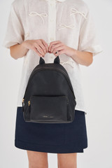 Profile view of model wearing the Oroton Lilly Small Backpack in Black and Pebble leather/Nylon for Women