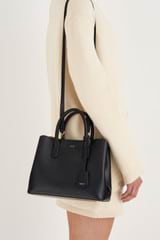 Profile view of model wearing the Oroton Muse Small Three Pocket Day Bag in Black and Saffiano And Smooth Leather for 