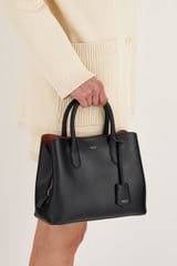 Profile view of model wearing the Oroton Muse Small Three Pocket Day Bag in Black and Saffiano And Smooth Leather for 